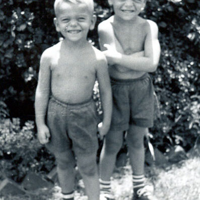 Billy Windsor and Tony Windsor posing next to shrubs in 1953.